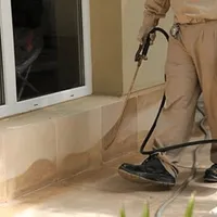 General pest control technician spraying exterior perimeter around a home in Austin, TX